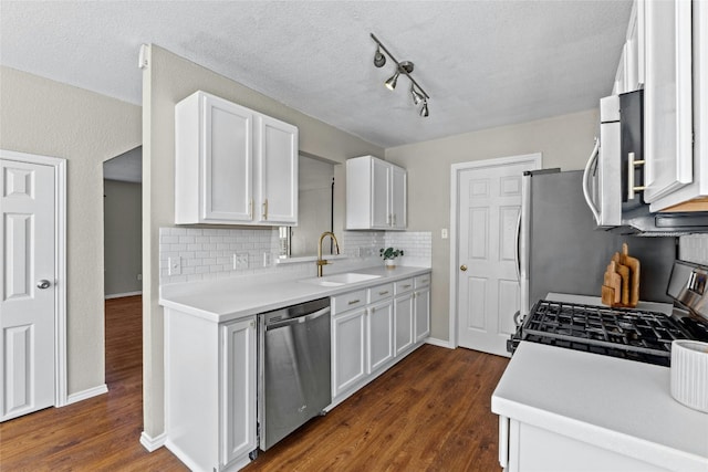 kitchen with dark hardwood / wood-style flooring, sink, white cabinets, and appliances with stainless steel finishes