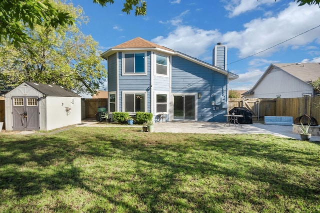 rear view of house with a yard, a storage unit, and a patio area