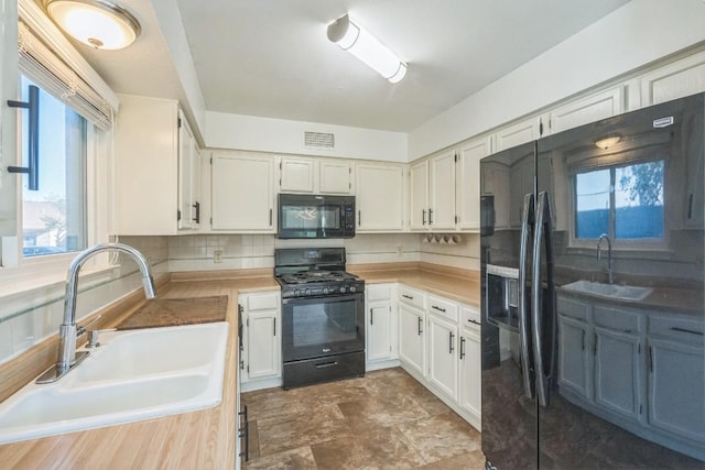 kitchen with sink, white cabinetry, a wealth of natural light, and black appliances