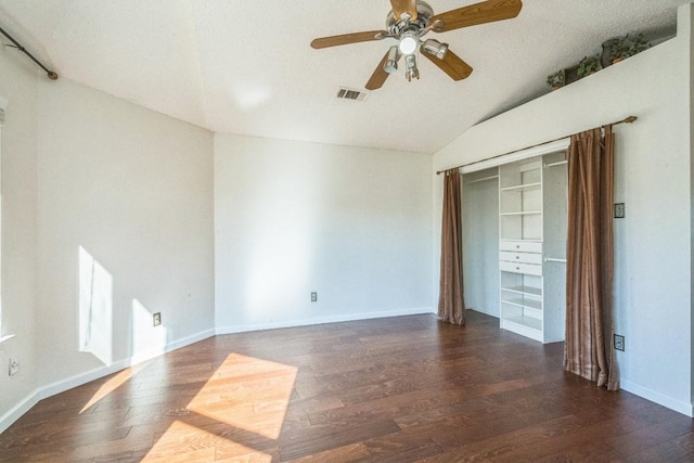 empty room featuring ceiling fan, dark hardwood / wood-style flooring, a textured ceiling, and vaulted ceiling