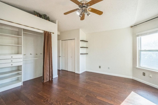 unfurnished bedroom with a textured ceiling, ceiling fan, and dark wood-type flooring