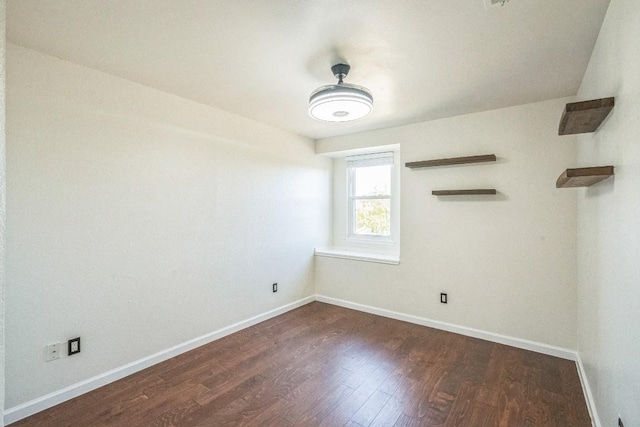 unfurnished room with dark hardwood / wood-style flooring