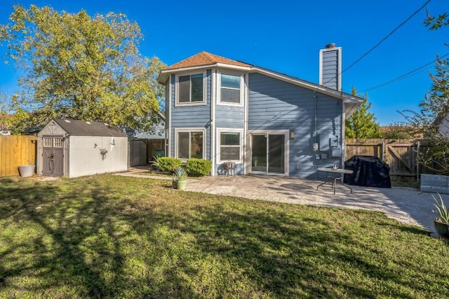 back of house featuring a storage shed, a yard, and a patio