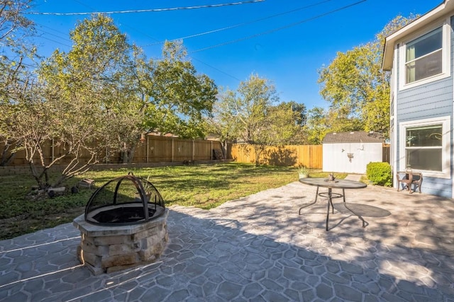 view of patio featuring a shed and a fire pit