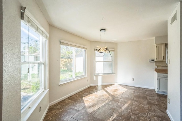 unfurnished dining area featuring an inviting chandelier