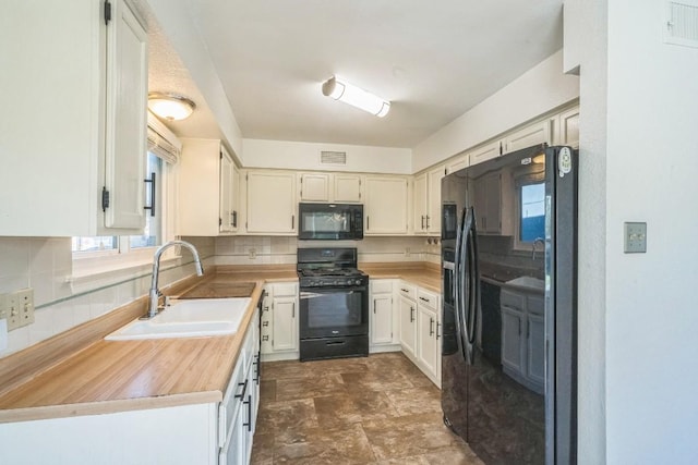 kitchen featuring white cabinets, sink, tasteful backsplash, and black appliances