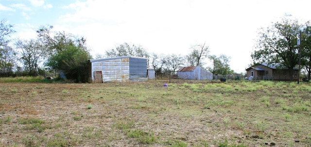 view of yard with fence and an outbuilding
