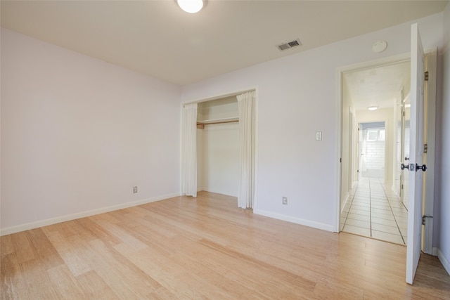 unfurnished bedroom with a closet and light wood-type flooring