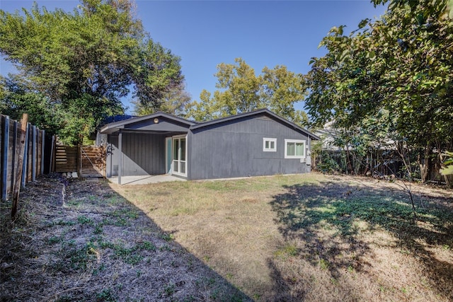 back of house with a lawn