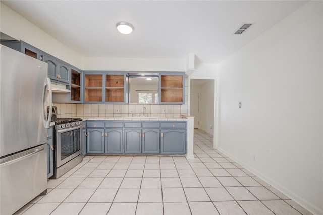 kitchen with backsplash, sink, light tile patterned flooring, and stainless steel appliances