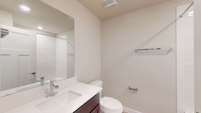 bathroom with a shower, vanity, and toilet