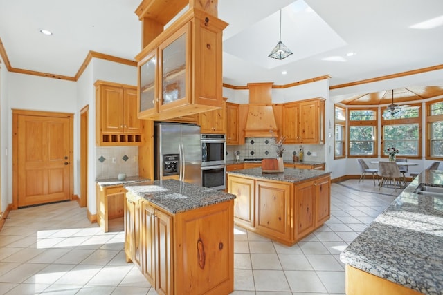 kitchen featuring a center island, hanging light fixtures, dark stone countertops, appliances with stainless steel finishes, and light tile patterned flooring