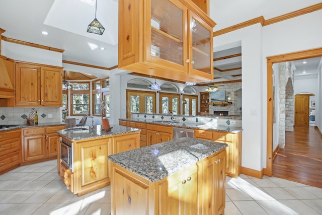 kitchen with kitchen peninsula, light tile patterned floors, a center island, and stone countertops