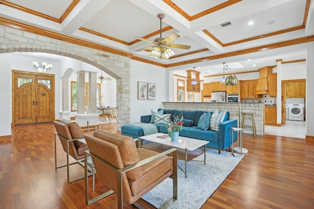 living room with hardwood / wood-style flooring, coffered ceiling, ceiling fan with notable chandelier, and washer / dryer