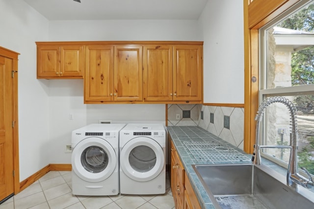 laundry area featuring a healthy amount of sunlight, light tile patterned floors, and sink