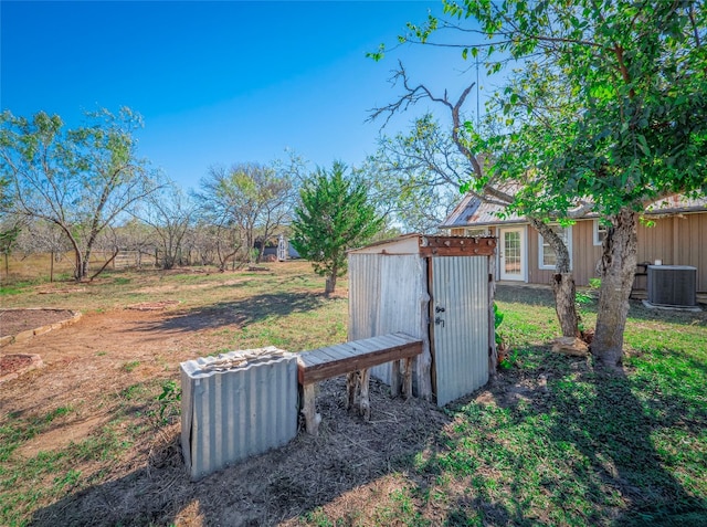 view of yard featuring a storage shed and central air condition unit