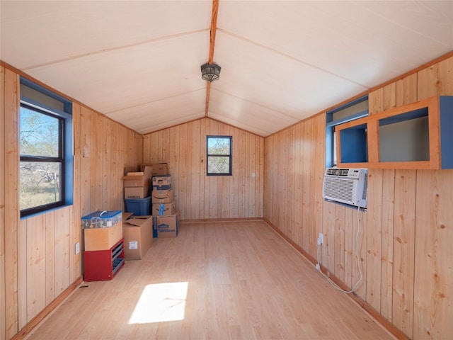 additional living space with wooden walls and light wood-type flooring