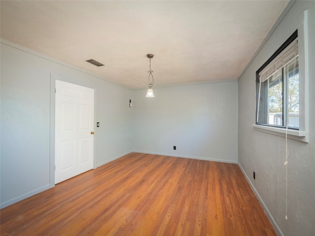 empty room featuring hardwood / wood-style flooring and crown molding