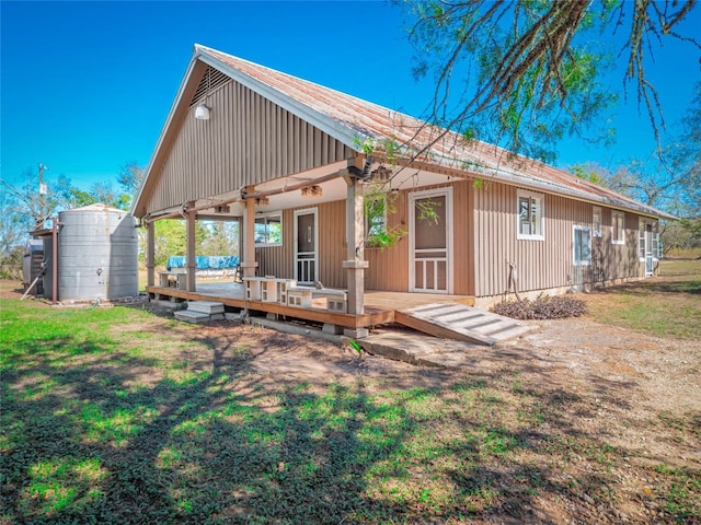 rear view of house featuring a wooden deck, a storage shed, and a lawn