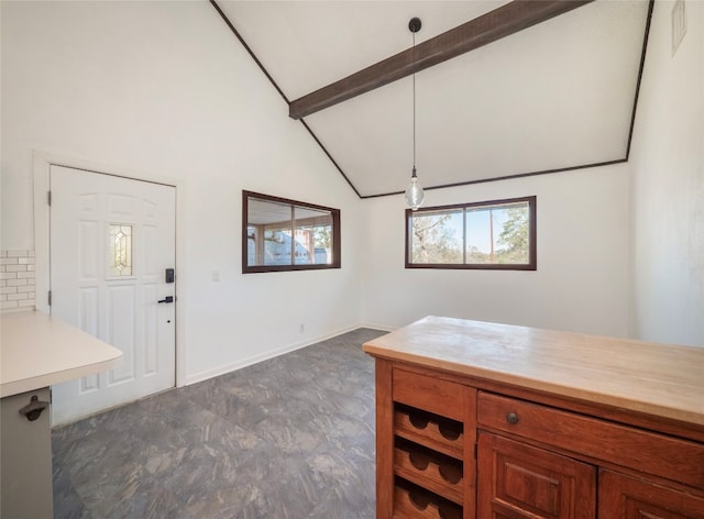 interior space with pendant lighting and vaulted ceiling with beams