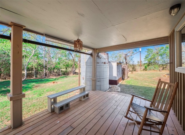 wooden deck featuring a lawn and a shed