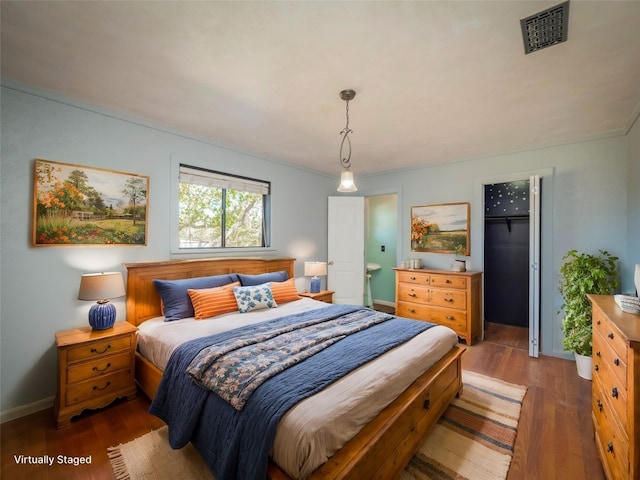 bedroom with dark hardwood / wood-style floors and ornamental molding