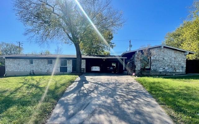 ranch-style house with a front lawn and a carport