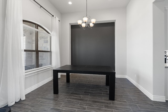 home office with dark wood-type flooring and a notable chandelier