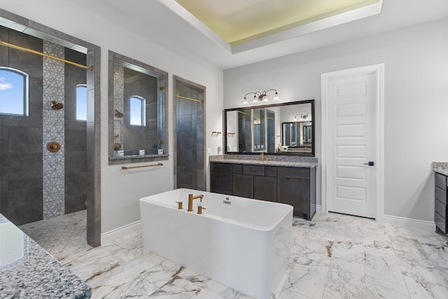 bathroom featuring vanity, separate shower and tub, and a tray ceiling