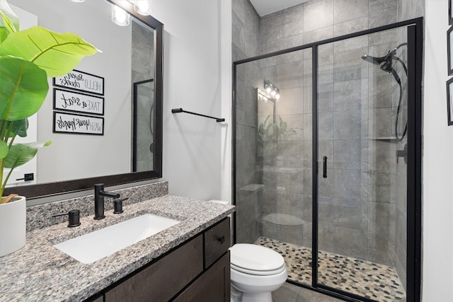 bathroom with vanity, an enclosed shower, and toilet