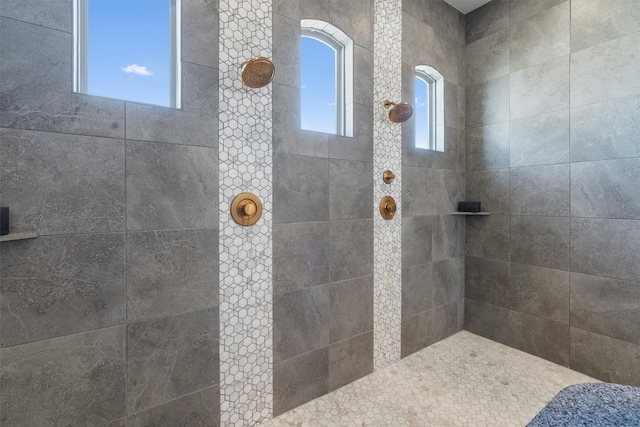 bathroom featuring tiled shower and a wealth of natural light