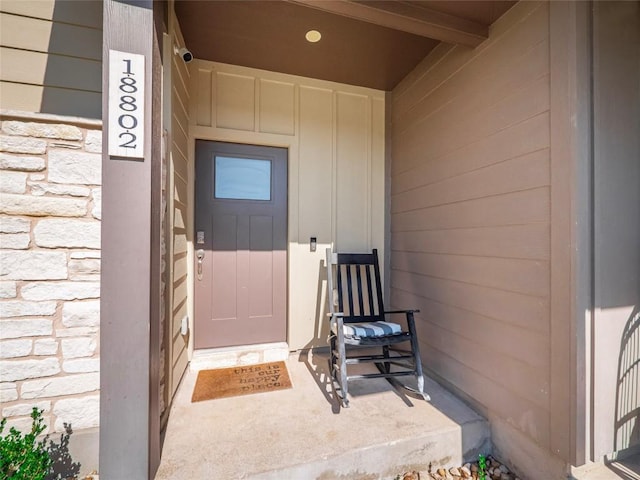 18802 Nicklaus Dr, Lago Vista, TX 78645 - view of exterior entry featuring stone siding and board and batten siding