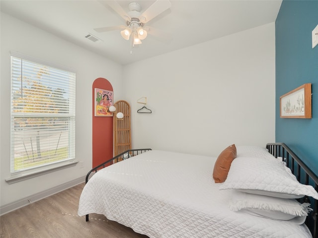 bedroom featuring light hardwood / wood-style flooring, multiple windows, and ceiling fan