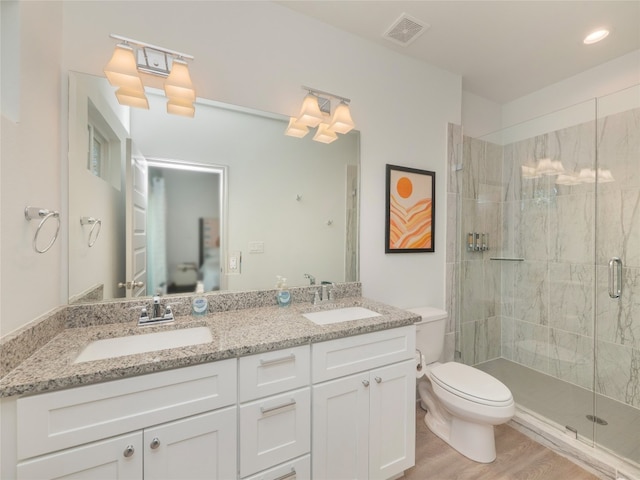 bathroom with wood-type flooring, vanity, toilet, and walk in shower