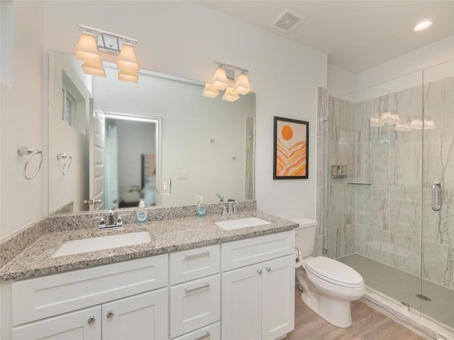 18802 Nicklaus Dr, Lago Vista, TX 78645 - bathroom featuring a stall shower, toilet, double vanity, and wood finished floors