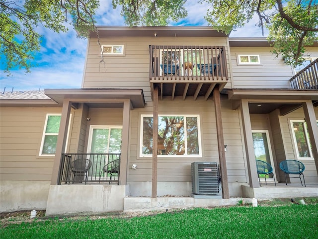 rear view of house featuring a balcony and cooling unit