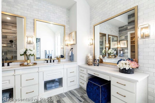 bathroom with vanity and brick wall