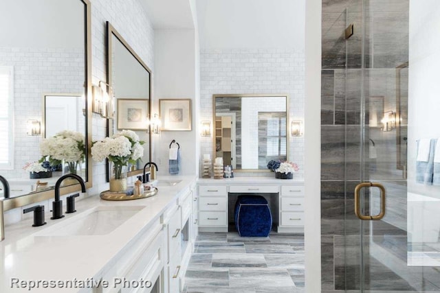 bathroom featuring vanity, walk in shower, and tile walls