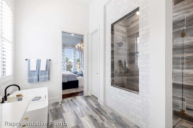 bathroom with hardwood / wood-style flooring, plenty of natural light, shower with separate bathtub, and an inviting chandelier