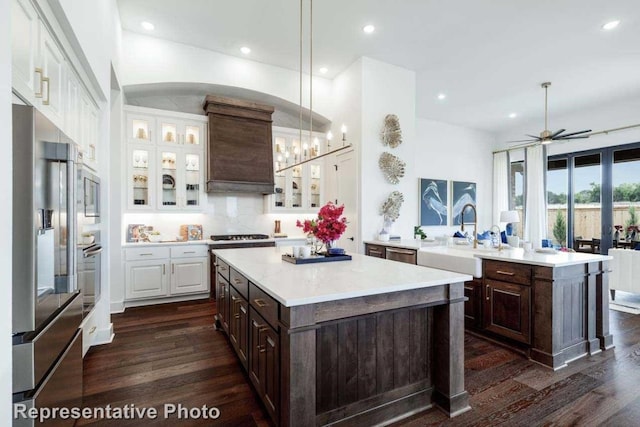 kitchen with a kitchen island, dark brown cabinetry, hanging light fixtures, and appliances with stainless steel finishes