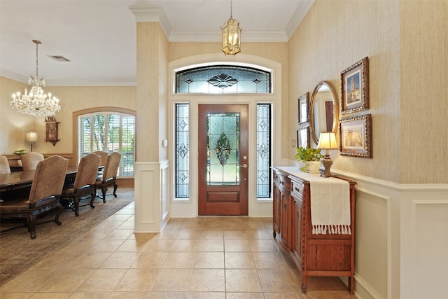 foyer entrance featuring crown molding and a notable chandelier