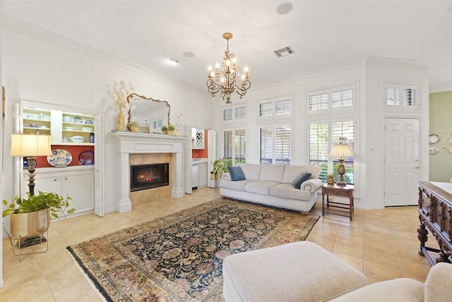 living room with an inviting chandelier, ornamental molding, light tile patterned floors, and a tiled fireplace