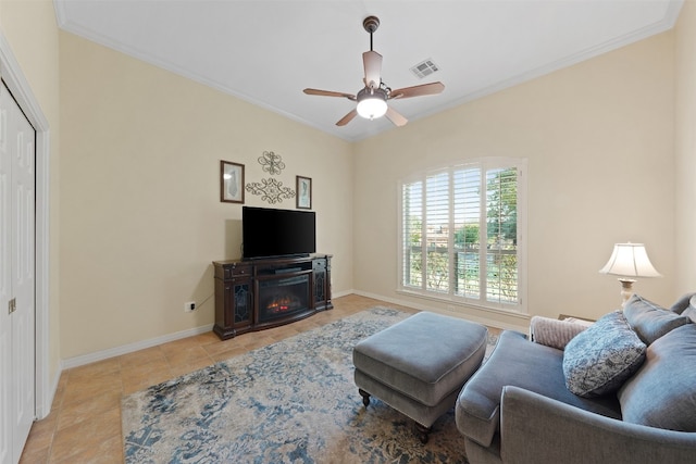 tiled living room featuring crown molding, a fireplace, and ceiling fan