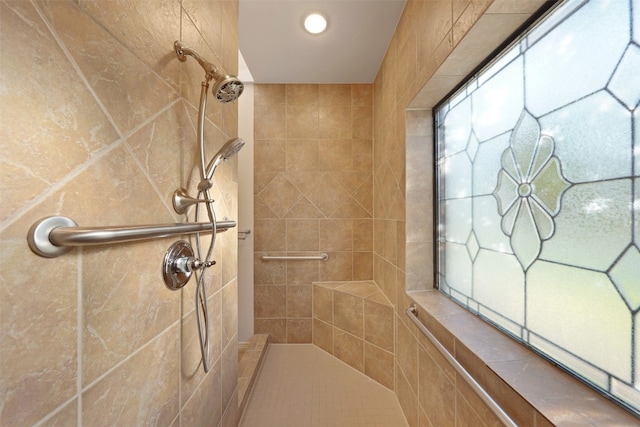 bathroom with tiled shower and tile walls