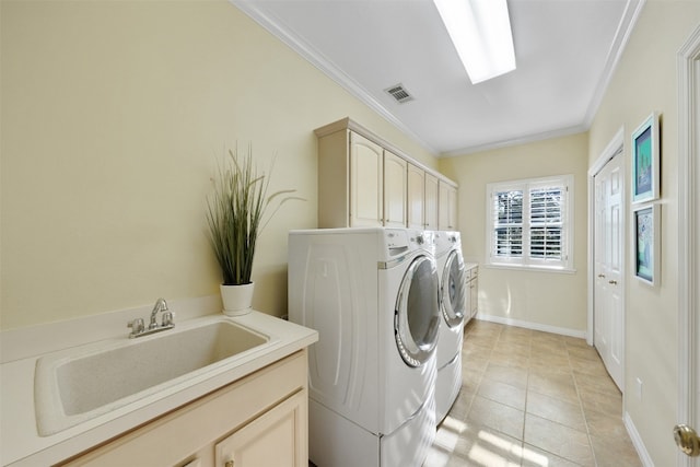 laundry area with cabinets, sink, washer and dryer, ornamental molding, and light tile patterned floors