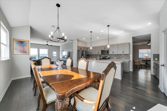 dining room featuring dark hardwood / wood-style floors and ceiling fan with notable chandelier