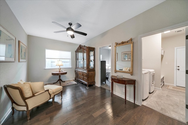 sitting room featuring hardwood / wood-style floors, washer and dryer, and ceiling fan