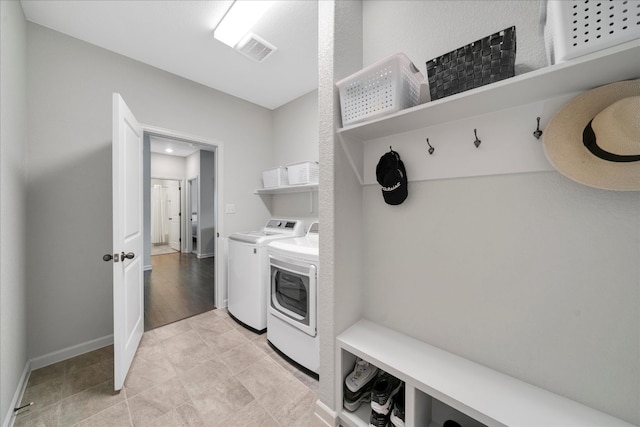 washroom featuring washing machine and dryer and light hardwood / wood-style flooring