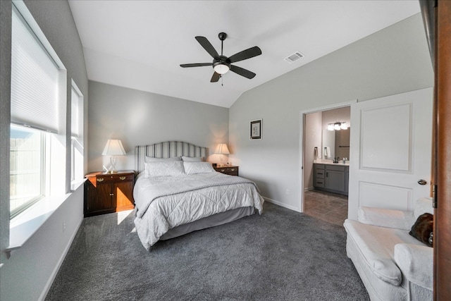 bedroom featuring ensuite bath, ceiling fan, sink, lofted ceiling, and dark carpet