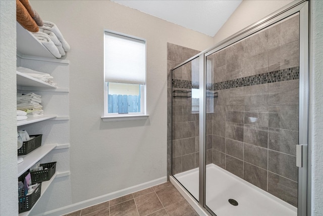 bathroom with tile patterned flooring, an enclosed shower, and lofted ceiling